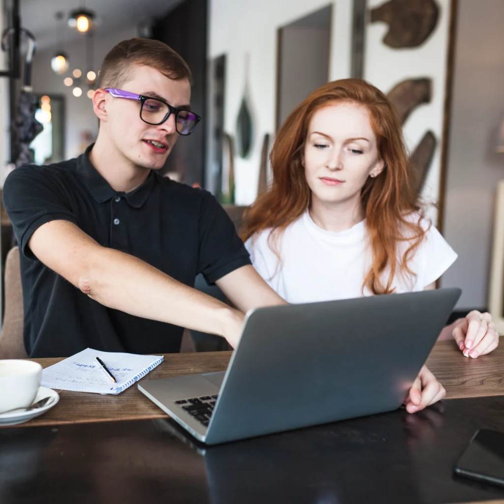man showing women laptop screen